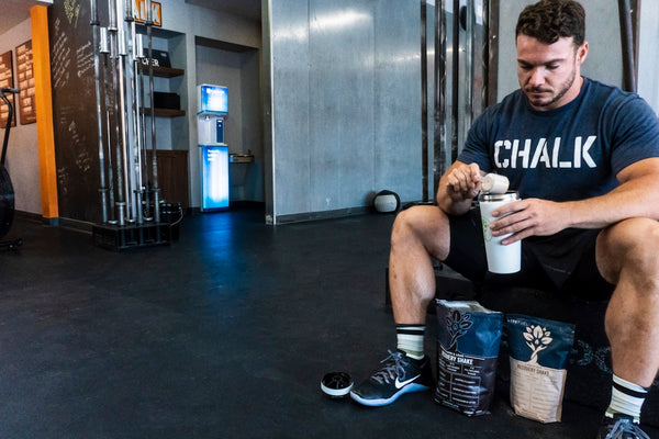 man in black crew neck t-shirt holding white plastic cup
