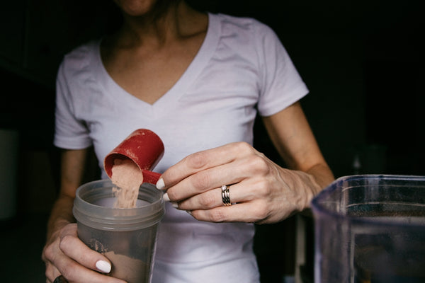 woman in white v neck shirt holding red heart shaped lollipop
