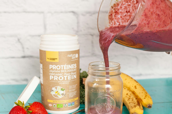 a person pouring a smoothie into a jar