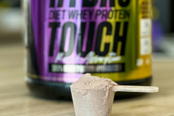 a jar of hydro protein and a spoon on a table