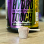 a jar of hydro protein and a spoon on a table