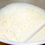 a large pot filled with white batter and a wooden spoon