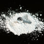 a scoop of powder next to a scoop of sugar