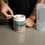 a man with a tattoo on his arm and a cup of coffee