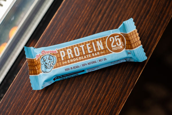 A protein bar rests on a wooden surface.