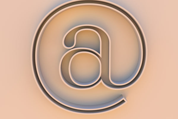 An at symbol on a beige background.