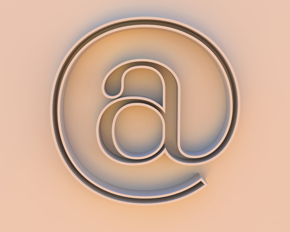An at symbol on a beige background.