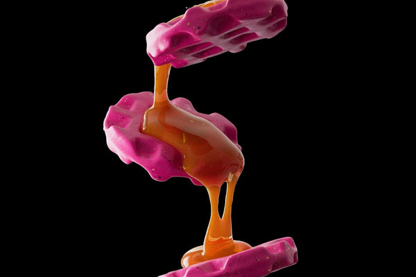 Pink waffles drizzled with a golden sauce.