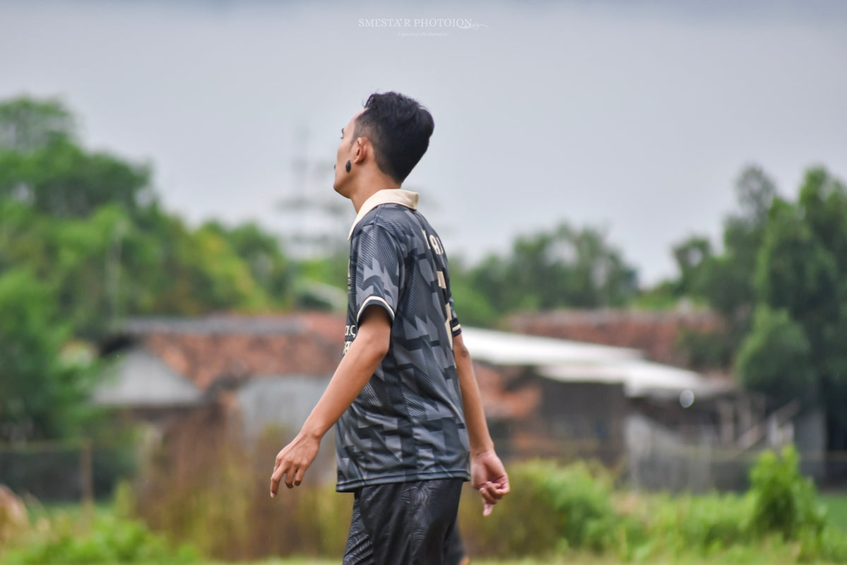 Young man in soccer jersey looks up at sky
